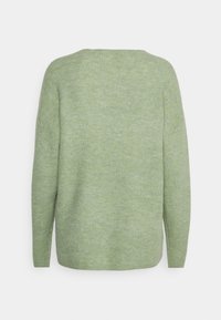 Pull vert tricoté à coupe ample, texture côtelée et manches larges. Présente un col rond et un aspect de tissu uni et doux.