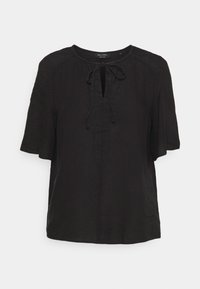 Top de lino negro con escote redondo, mangas cortas y un detalle de lazo en la parte frontal. Cuenta con una tapeta parcial y un corte holgado. Diseño simple y sin adornos.