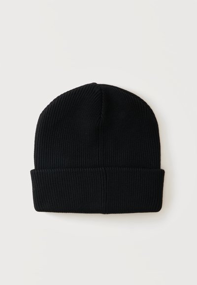 Bonnet noir tricoté avec bord replié, présenté à plat sur un fond uni clair.