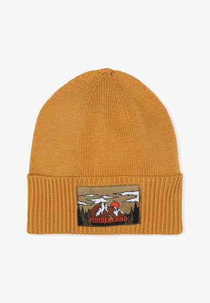 Gehaakte mosterdgele beanie met een geribbelde manchet, voorzien van een patch met bergen en een zonsondergang, met "TIMBERLAND" in vetgedrukte letters.