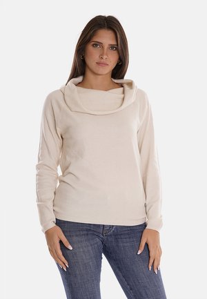 Top lungo beige con maniche lunghe, caratterizzato da un collo a cascata e una texture in maglia morbida. Il design ha una vestibilità comoda, con un dettaglio di cucitura discreto sul corpo.