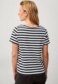 Zwart-wit gestreept T-shirt met korte mouwen en een ronde halslijn. De stof lijkt licht en zacht te zijn.