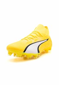 Gelbe Fußballschuhe mit strukturiertem Obermaterial, schwarzem und weißem Akzentdesign sowie durchsichtigen Noppen für besseren Halt. Abgerundete Zehenpartie und Schnürverschluss.