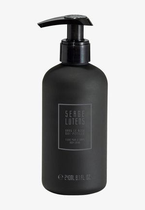 Bottiglia nera opaca con dispenser a pompa, caratterizzata da un testo bianco minimalista. Volume 240 ml, etichettata come latte corpo da Serge Lutens.