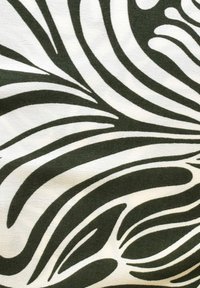 Design astratto di tessuto caratterizzato da flussi di motivi a forma di foglia di colore verde scuro e bianco su una superficie liscia e testurizzata.