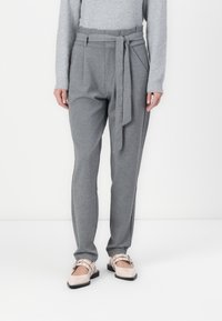 Grå, høy midje bukser med en knyttet beltedetalj, glatt tekstur, smal ben og sidelommer. Bært med lyse slip-on sko.
