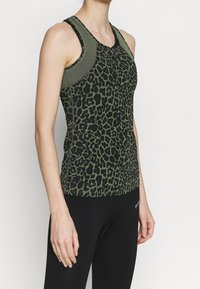 Groene luipaardprint tanktop met een slim fit ontwerp, featuring zwarte schouderaccenten en een zachte textuur, gecombineerd met zwarte leggings.
