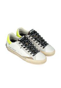 Sneaker in pelle bianca con lacci neri con logo, dettagli in suede grigio e particolare sul tallone in giallo neon. Suola in gomma con motivo a stella.