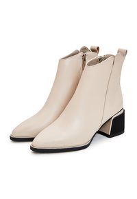 Botine bej până la glezină, realizate din piele netedă, cu vârfuri ascuțite, fermoar pe lateral și toc bloc texturat.