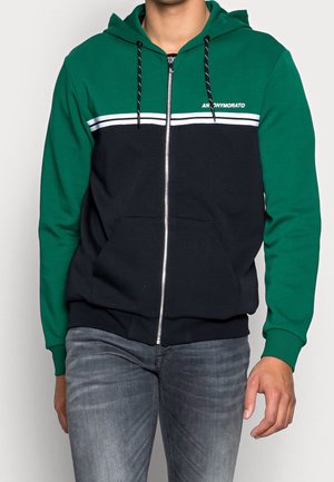 Zwarte en groene rits-hoodie met een capuchon, voorzien van een witte streepdesign over de borst en een kangoeroezak. Gemaakt van een katoenmix met ribgebreide manchetten.