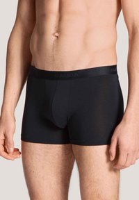 Zwarte boxershorts gemaakt van een gladde stof met een aansluitend ontwerp. Voorzien van een zachte tailleband met reliëf merknamen en een gecontourde pouch.