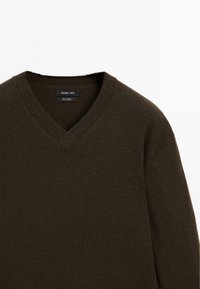 Maglione a V in una ricca tonalità di marrone scuro, realizzato in morbido tessuto a maglia con dettagli a coste sul collo. Design semplice e moderno.
