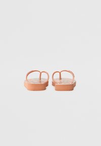 Flip-flops with a pink, textured sole and dual strap design. The insole features a colorful floral pattern. Flat base with a rounded shape.