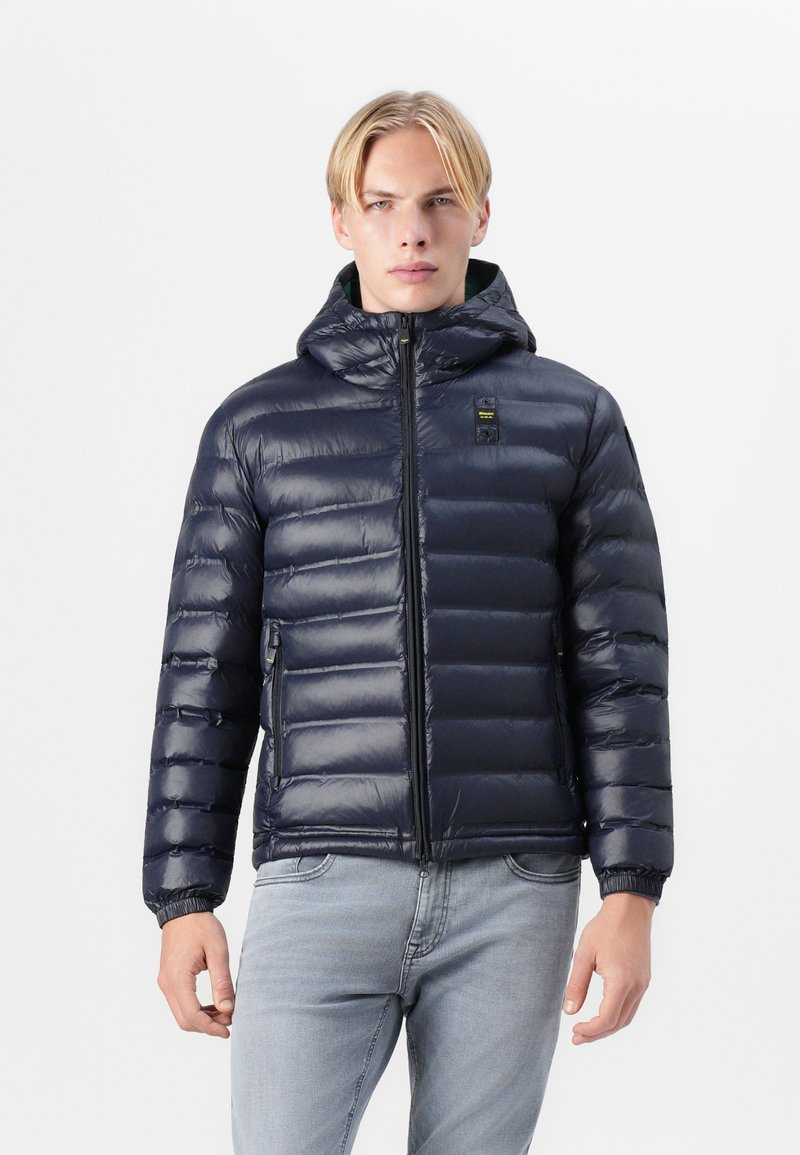 Navy blue puffer jacket with a zippered front, removable hood, and elastic cuffs. Made from glossy, lightweight material with quilted padding.