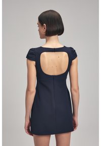 Vestido azul marino con mangas cortas abullonadas, diseño de espalda descubierta y cierre de cremallera. Hecho de tela texturizada, corte a la altura de la rodilla.