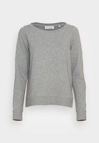 Sudadera gris hecha de tela suave, con cuello redondo, mangas largas y un dobladillo ligeramente recortado. Etiqueta visible en el interior.
