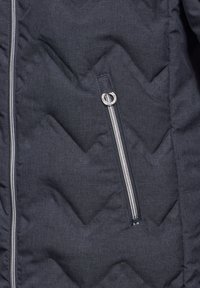 Quiltad mörkgrå jacka med diagonalt chevronmönster, silverdragkedja med rund draghandtag och sidofickdetalj.