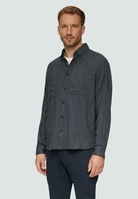 Donkerblauwe herringbone overhemd met knopen, twee borstzakken, kraag en lange mouwen. Heeft een ontspannen pasvorm met een gestructureerd oppervlak.