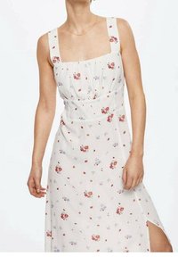 Robe maxi florale en tissu léger, avec un décolleté carré, des bretelles ajustables, une base blanche et des motifs de fleurs rouges et violettes dispersés.