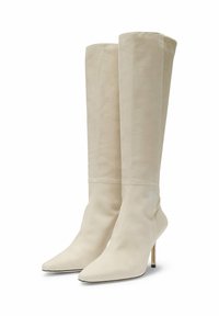 Botas de ante beige hasta la rodilla con punta puntiaguda, forma cónica y tacón metálico delgado. Textura lisa sin patrones visibles.