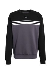 Pulover majica s raglan rukavima. Crni rukavi, sivo tijelo s tri bijele pruge preko prsiju. Mješavina pamuka, okrugli izrez.