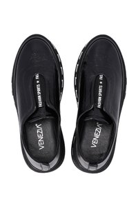 Schwarze Sportschuhe mit elastischen Seitenpaneelen, glattem Synthetik-Obermaterial, strukturiertem Innensohle und kontrastierenden weißen Sohlenakzenten mit einem Logo.