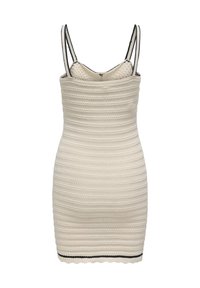 Mini-robe sans manches, tricotée en blanc cassé avec des rayures horizontales texturées, fines bretelles bordées de noir et une ligne noire près de l'ourlet festonné.