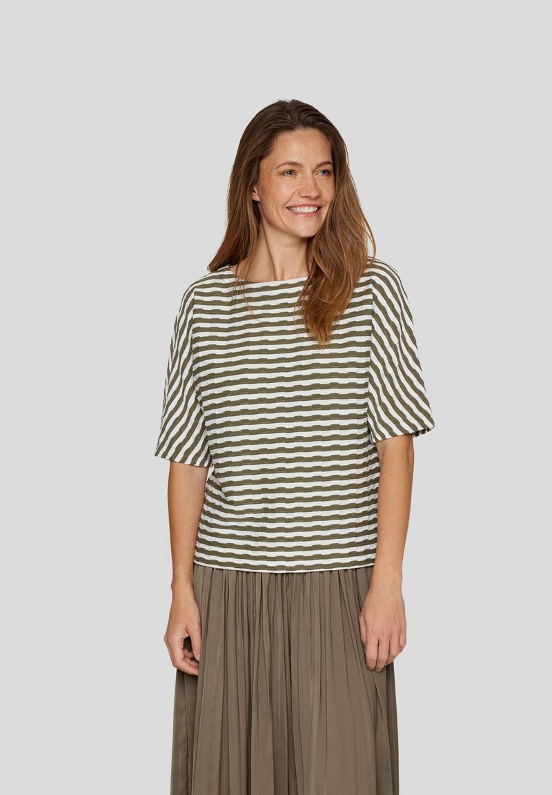 Striped top in olive green and white, short sleeves, relaxed fit, textured fabric. Paired with a flowy, matching skirt.