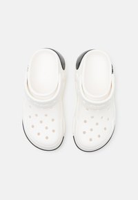 White clogs with black heel accents, ventilation holes, and a textured footbed. Made of lightweight material for comfort and breathability.