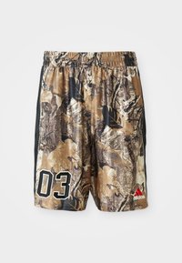 Calções camuflados com um cós elástico, apresentando uma mistura de castanhos e pretos, um grande "03" em branco e um logótipo da Adidas em vermelho.