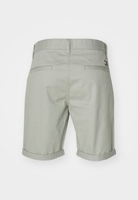 Shorts di cotone verde chiaro con orlo risvoltato, due tasche posteriori e un piccolo logo ricamato sulla vita.