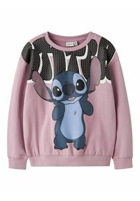 Różowa bluza z długim rękawem z postacią z kreskówki Stitch, która się uśmiecha, oraz dużym, czarno-białym wzorem tekstu na górze klatki piersiowej.