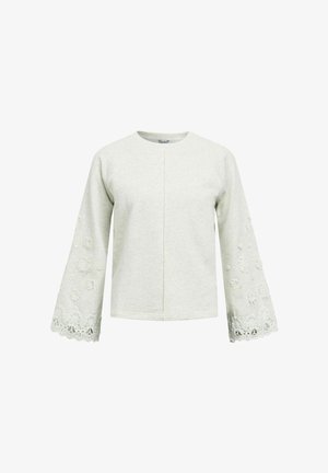 Gaiši pelēks garām piedurknēm tops ar platām piedurknēm, kurām ir ziedu mežģīņu un izšuvumu detaļas pie aprocēm un apakšējām piedurknēm.