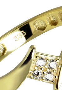 Bague en or avec finitions texturées, accents hexagonaux et quatre pierres claires serties sur un anneau poli. Marquée "333" pour la pureté.