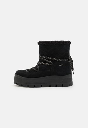 Botas negras hasta el tobillo de ante, con una parte superior texturizada, un collar suave, suela gruesa y cordones en contraste.