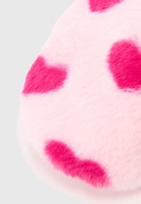 Pink plush slipper with soft fur texture, featuring large, vibrant pink heart patterns on a light pink background. Round shape design.
