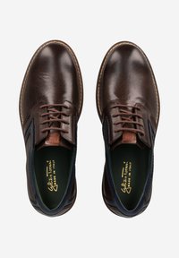 Chaussures en cuir marron avec une finition texturée, bout rond et accents latéraux contrastants en bleu marine. Elles sont dotées de lacets marron et d'une semelle intérieure rembourrée.