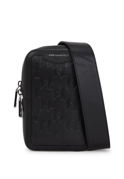 Sac bandoulière noir avec une surface texturée ornée de motifs géométriques, une sangle ajustable et des détails en métal.