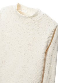 Haut à manches longues crème clair avec un col montant, texture côtelée et éclats d'or dispersés. Design simple sans matériel visible.