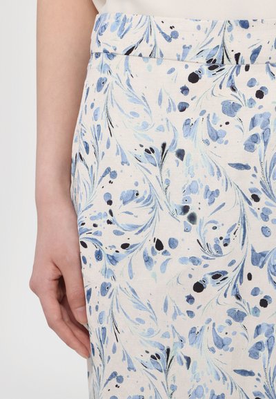 Hvit stoff med blå og svarte blomstermønstre, med en avsmalnet design og en linning. Teksturen ser glatt ut og er noe teksturert.
