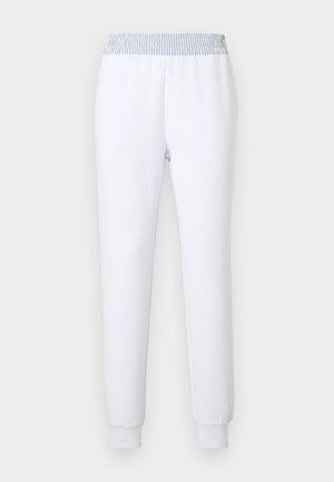 Hvide joggingbukser med en stribet blå elastisk linning. Konisk ben, blød tekstur og ribkantsmanchetter for en behagelig pasform.