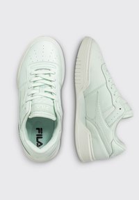 Jasno miętowe sneakersy z gładką skórzaną cholewką, perforowanym noskiem, białymi akcentami i teksturowanymi podeszwami. Widoczne sznurowadła i siateczkowe wnętrze.