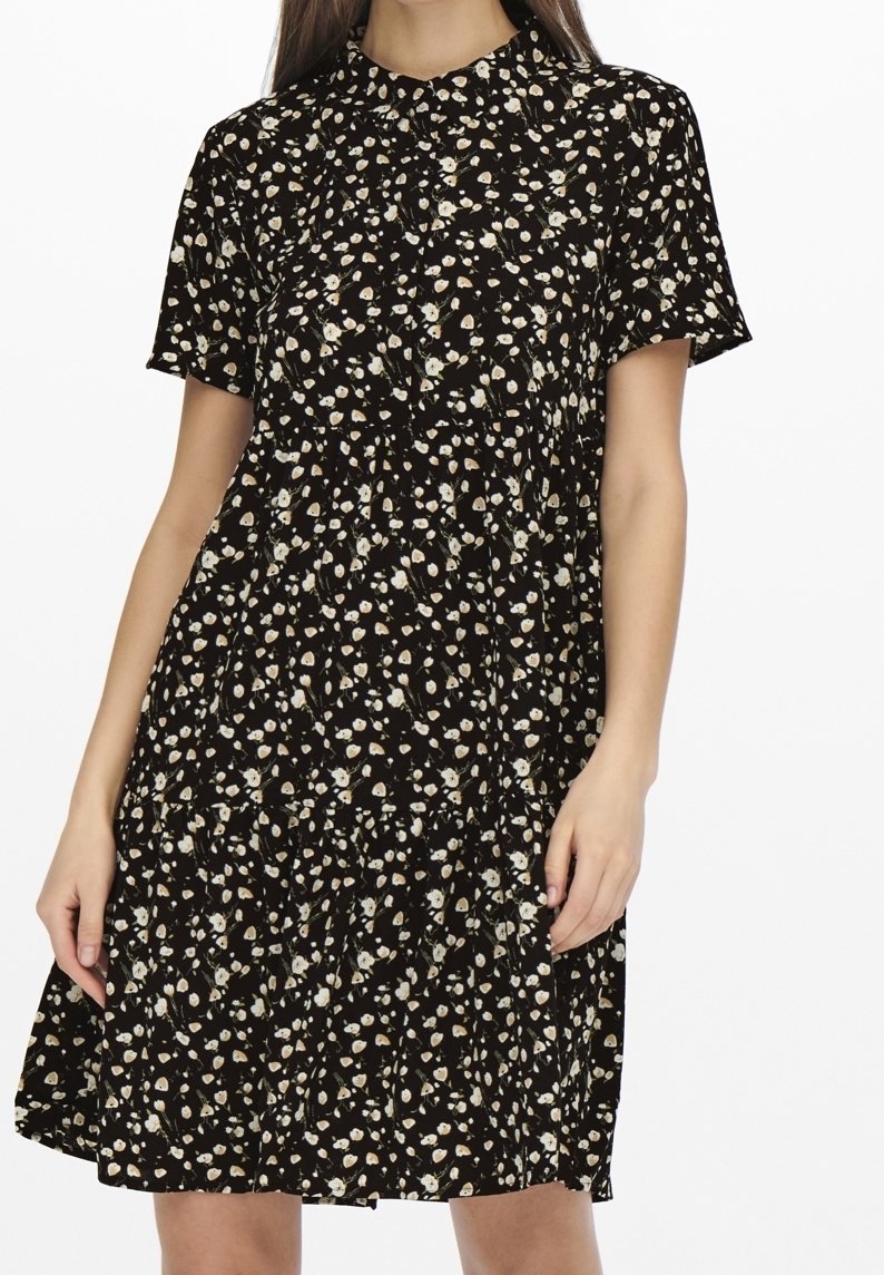 Abito nero a fiori con maniche corte, colletto con bottoni, design a strati, caratterizzato da piccoli motivi floreali bianchi e beige su uno sfondo scuro.