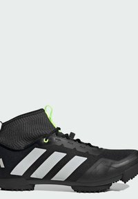 Baskets de sport noires avec un col en tricot texturé, dotées d'une semelle en caoutchouc durable, d'un design à trois bandes blanches et d'accents de lacets vert fluo.