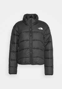 Svart puffjacka med hög krage, dragkedja och logotypdetalj. Har ett quiltat mönster och sidofickor. Mjuk tygstruktur.