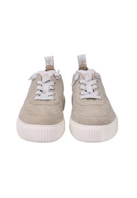 Beżowe zamszowe trampki z grubymi białymi gumowymi podeszwami, białymi sznurowadłami oraz materiałowymi pętelkami z tyłu, widoczne z przodu.