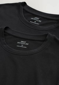 To sorte bomulds t-shirts stablet, med rund halsudskæring, glat tekstur, og mærker der viser brand og størrelsesdetaljer.