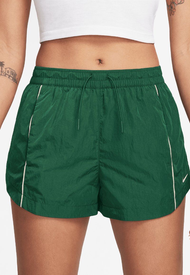 Shorts de sport verts en tissu léger, dotés d'une taille élastique, d'un cordon de serrage et d'accents latéraux blancs pour le contraste.