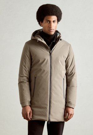 Parka beige con capucha, cierre frontal, dos bolsillos laterales y puños elásticos. Material suave con acabado mate.