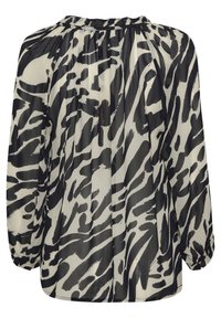Průhledná blůza s dlouhými rukávy, která má monochromatický vzor zebra. Tkanina je lehká a má nařasený límec a elastické manžety.